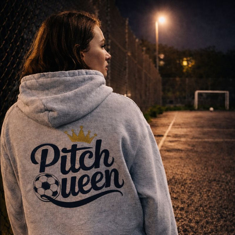Person wearing a hoodie with 'Pitch Queen' text on a dark outdoor setting
